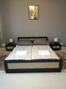 łóżko w pokoju z dwoma stolikami nocnymi i dwoma stołami w obiekcie Apartament Równica w Ustroniu