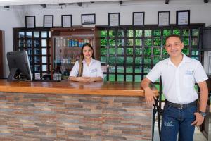 un hombre y una mujer de pie en un bar en Hotel Villa Camila en La Pintada