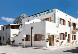 a white building with a sign on top of it at Hotel Baia Di Venere in San Vito lo Capo