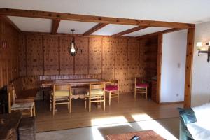 - une salle à manger avec des murs en bois, une table et des chaises dans l'établissement Majestic 424, à Bagnes