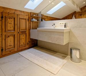 ein Badezimmer mit einem Waschbecken und einer Theke mit einem Teppich in der Unterkunft Freihaus Brenner in Bad Wiessee