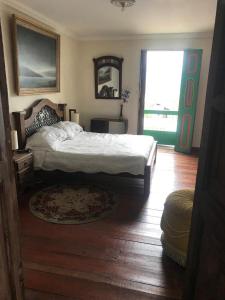 1 dormitorio con cama grande y ventana grande en Hotel Colonial - Salamina Caldas, en Salamina