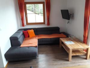 ein Wohnzimmer mit einem Sofa und einem Tisch in der Unterkunft Knollnwies in Alpbach