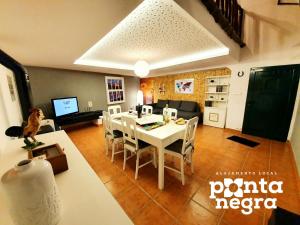 - une salle à manger et un salon avec une table et des chaises dans l'établissement Alojamento Ponta Negra, à Biscoitos
