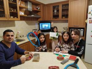 a group of people sitting at a table in a kitchen at Petit Dilijan in Dilijan