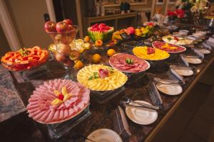 a buffet with many plates of food on a table at Hotel Renar in Fraiburgo