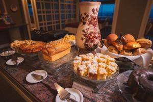 uma mesa com diferentes tipos de pastelarias e tartes em Hotel Renar em Fraiburgo