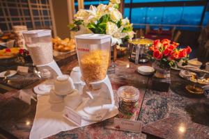 einen Tisch mit Blumen und einem Mixer darauf in der Unterkunft Hotel Renar in Fraiburgo