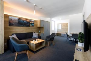 a living room with a couch and chairs and a table at Sporthotel Olympia in Stachy