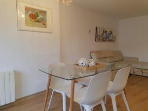 a dining room with a glass table and white chairs at Casco Histórico, con Parking incluido in Zaragoza +14 photos