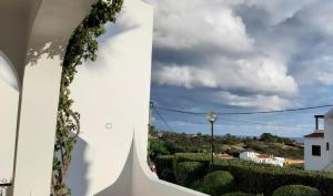 a view from the side of a white building with bushes at Apartamento Neptuno in Benagil
