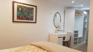 a bedroom with a bed and a vanity and a mirror at Casco Histórico, con Parking incluido in Zaragoza