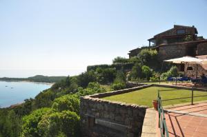 a house on a hill with a view of the water at Villaggio Est a Capo Coda Cavallo San Teodoro in San Teodoro