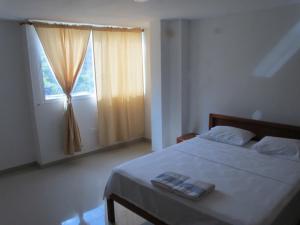 a bedroom with a large bed with a window at Casa Luna Hotel in Taganga