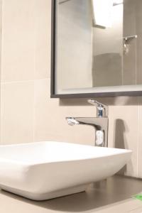 a white sink in a bathroom with a mirror at Hotel d'Alcantara in Tournai