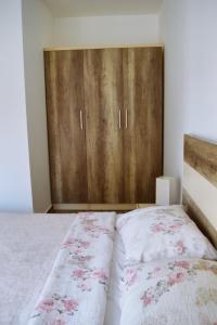 a bedroom with a bed and a wooden cabinet at Apartments Nikčević in Budva