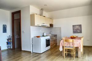 a kitchen with a table and a white refrigerator at Apartments Nikčević in Budva