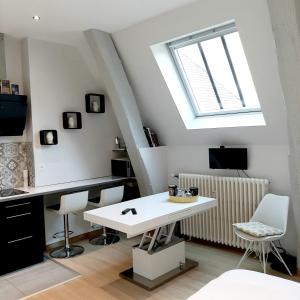 - un salon avec une table blanche et une fenêtre dans l'établissement Studio Jean LEBELIN, à Dijon