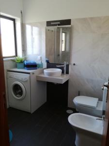 uma casa de banho com um lavatório e uma máquina de lavar roupa em Buarcos Beach House em Buarcos