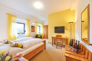 a bedroom with a bed and a desk and a television at Gästehaus Achenbach in Wonsheim