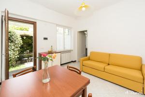 ein Wohnzimmer mit einem gelben Sofa und einem Tisch in der Unterkunft A Durmì in Levanto