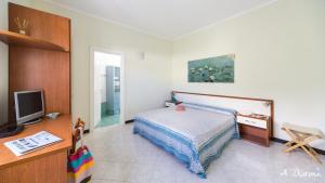 a small bedroom with a bed and a tv at A Durmì in Levanto