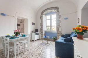 - un salon avec un canapé bleu et une table dans l'établissement Bosa Il Borgo E6368, à Bosa