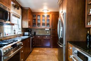 een keuken met houten kasten en een roestvrijstalen koelkast bij The Fillmore Inn in Twin Falls