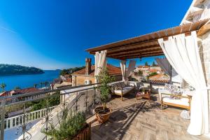 a house with a balcony with a view of the water at Dubrovnik-Cavtat Villa Mima -Sea front Villa with pool in Cavtat