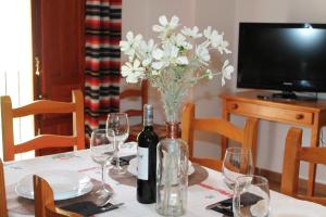 einen Tisch mit zwei Flaschen Wein und einer Vase Blumen in der Unterkunft Apartamento Rurales Rosendo: Poleo Menta in Capileira