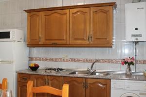 a kitchen with wooden cabinets and a sink at Apartamento Rurales Rosendo: Poleo Menta in Capileira