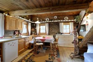 エルフェンドルフにあるApartment Landhaus Mühlau in Tirolのテーブル付きのキッチン、木製の天井が備わるキッチン