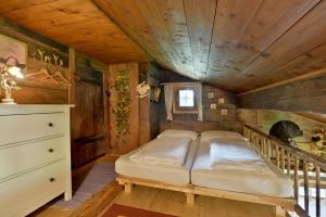 a bed in a room with a wooden ceiling at Apartment Landhaus Mühlau in Tirol in Erpfendorf