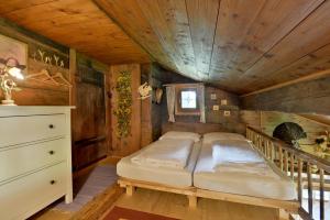Łóżko w pokoju z drewnianym sufitem w obiekcie Apartment Landhaus Mühlau in Tirol w mieście Erpfendorf