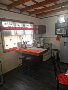 a kitchen with a counter with stools and a sink at Apartamento 11 Tec in Cartago +7 photos