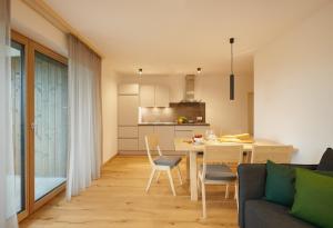 uma cozinha e sala de estar com mesa e cadeiras em Ariala - Mountain Holiday Home em Falzes