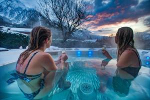 Dos mujeres en un jacuzzi con bebidas en Chalet Tissières, en Chamonix-Mont-Blanc