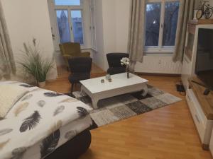 a living room with a couch and a coffee table at Pension Altenburg City in Altenburg +3 photos