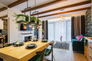a kitchen and living room with a table and a couch at Apartament Marron - Skrzyczne in Szczyrk