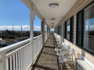 a porch with chairs and windows on a house at Sea Horse Inn and Cottages in Nags Head