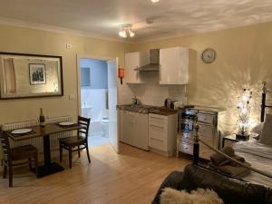 a kitchen and living room with a table and a couch at Southernwood - Studio 2 in Didcot