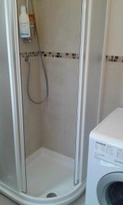 een douche in een badkamer naast een wasmachine bij La VillEtta in Bordighera
