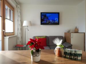 ein Wohnzimmer mit einem Sofa und einem Tisch mit Blumen in der Unterkunft Ferienhaus Karin in Ramsau am Dachstein