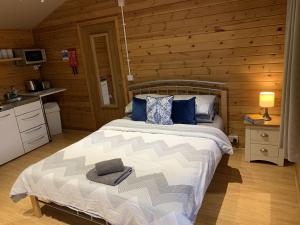 um quarto com uma cama num chalé de madeira em Southernwood - Garden Lodge 1 em Didcot