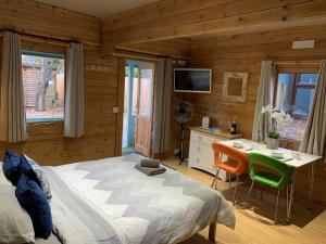 um quarto com uma cama, uma mesa e cadeiras em Southernwood - Garden Lodge 1 em Didcot