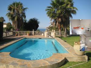 a swimming pool in the backyard of a house at Villa Flor de Azahar in Benalmádena