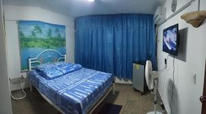 a bedroom with a bed and a blue curtain at Apartamento UltraMar in Matanzas