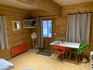 a room with a table and chairs in a cabin at Southernwood - Garden Lodge 2 in Didcot