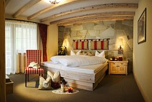 a bedroom with a large bed with a stone wall at Hotel Montanara in Ischgl