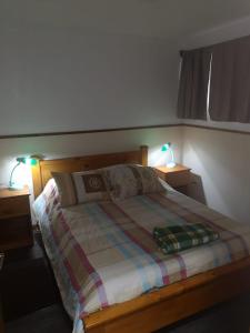 a bedroom with a bed with two lights on two tables at Apartamento 11 Tec in Cartago